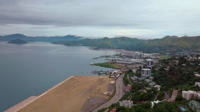 Port Moresby Harbour Marina Papua New Guinea aerial drone morning cloudy foggy sunrise PNG Crown Hotel Plaza Hilton Ela Beach Walter Bay car traffic Coral Sea coastline capital city forward motion