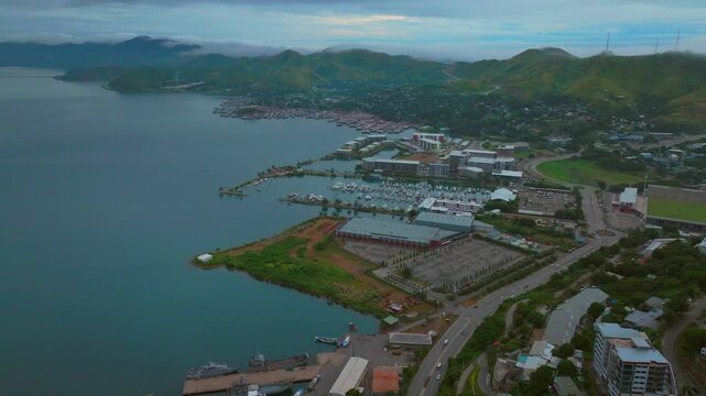 Port Moresby Harbour Papua New Guinea aerial drone morning cloudy foggy sunrise PNG Crown Hotel Plaza Hilton Ela Beach Walter Bay rainy Coral sea coastline capital city mountains backwards motion