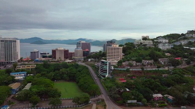 Morning cloudy foggy sunrise Port Moresby Harbour Crown Hotel Plaza Hilton Ela Beach Papua New Guinea aerial drone PNG Walter Bay rainy Coral sea coastline capital city mountains forwards motion