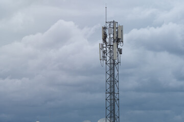 Telephone signal tower with a background of blue clouds.
