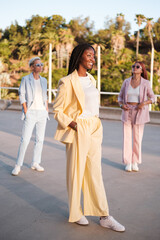 Woman in a yellow suit surrounded by her fellow businesswomen in colorful suits. Business, leadership