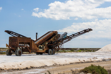 Gruissan, France. 05-22-2024.  Pile of sand and machine  in the salt ponds at Gruissan, France.