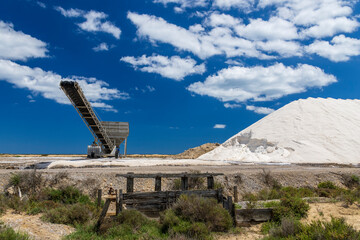 Gruissan, France. 05-22-2024.  Pile of sand and machine  in the salt ponds at Gruissan, France.