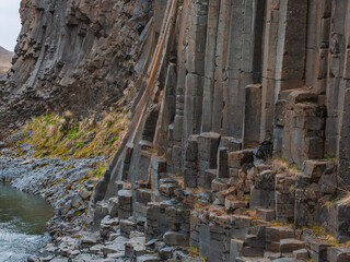 Fototapeta premium A low-angle view of weathered and eroded basalt columns in Iceland, showcasing their hexagonal pattern and rough texture formed by cooling lava.