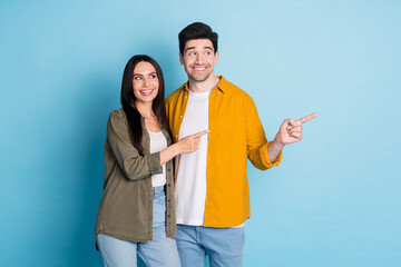 Photo of two nice young partners look direct fingers empty space wear shirt isolated on blue color background