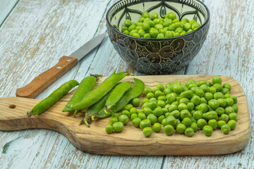 tas de petits pois crus sur une table	