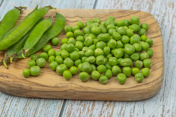 tas de petits pois crus sur une table	