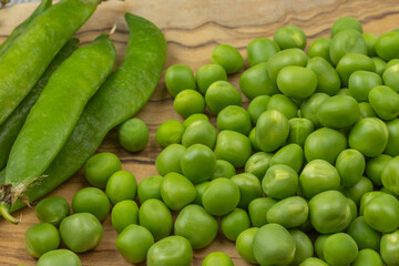 tas de petits pois crus sur une table	