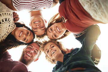 Low angle, portrait and team of happy friends together outdoor for bonding, solidarity and community. Face, below and group of people huddle for collaboration, support and smile of students in circle