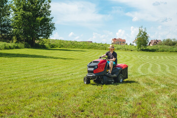 Man on lawn tractor mowing lawn on backyard. The red rider. The lawnmower tractor. High quality 4k footage