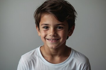 Portrait of a boy dark hair with brown eyes in a white T shirt smiling. Creative banner. Copyspace image