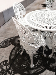 Obraz premium openwork white metal tables and chairs 