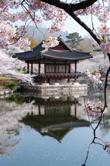 Fototapeta premium A serene hanok by a tranquil pond, cherry blossoms in full bloom and sunlight streaming through the trees, capturing the essence of spring