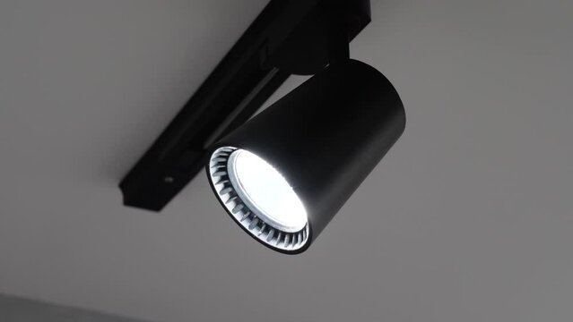 Spot track led lamp loft on the ceiling. Slide in slow motion. Electricity chandelier, modern black.