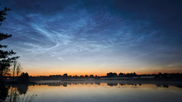 silver clouds shake the lake on a bright summer night