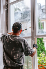 A man is cleaning a window with a squeegee