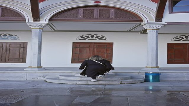 A woman explores ottoman architecture at topkapi palace, istanbul, encapsulating tradition, history, and travel in turkey.