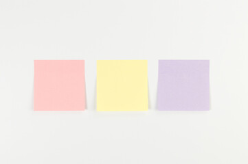 Top view of colorful sticky notes on white background. School, office wallpaper. Flat lay, copy space.
