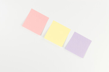 Top view of colorful sticky notes on white background. School, office wallpaper. Flat lay, copy space.