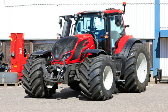 Red Valtra T235 tractor parked outside at the agricultural machinery dealership. 