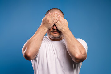 man covering his eyes with his hands