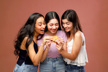 Three Slim Beautiful Women Holding A Burger And Looking At It