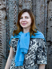 A close-up portrait of a young woman enjoying the natural beauty of a forest setting. Ideal for themes of mindfulness, serenity, and connection with nature