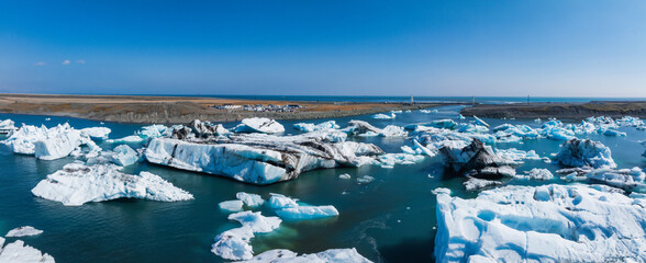 Aerial view of the big pieces of ice from glacier, ice islands, glacier and mountains, Jokulssrlon - Glacier Lagoon. A large glacial lake in southern part of Vatnajokull National Park, Iceland