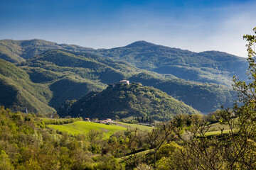 Fototapeta premium A view of Mount Antuni on Lake Turano, near the village of Castel di Tora, Rieti, Lazio, Italy. The uninhabited village stands in the center of the lake, surrounded by green mountains.