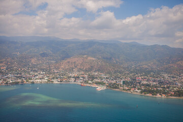 Fototapeta premium Aerial view of Dili City, the capital of Timor Leste. Urban settlements with a beach in the foreground and hills in the background.