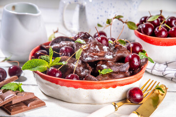 Sweet dessert chocolate dumplings vareniki with cherry berries and chocolate sauce, with sugar powder. Traditional ukrainian, polish, east european pierogi dumplings