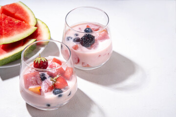 Subak Hwachae cocktail, Korean traditional watermelon punch salad drink, with a lot of fruit slices, with tapioca boba pearls, in glass and bowl for party, copy space