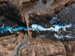 Majestic summer aerial view of Bruarfoss Waterfall. The Icelands Bluest Waterfall. Blue water flows...