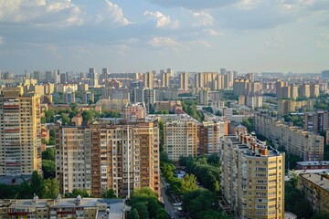Fototapeta premium A cityscape with tall buildings and a cloudy sky