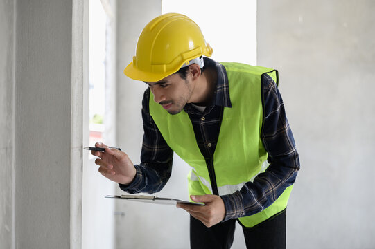 Male civil engineer with inspection check sheet consult with construction site foreman technician for inspect building condition defect pointing wall crack wait for repair.