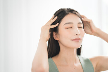 両手でヘッドマッサージをする女性