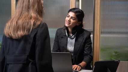 happy young smiling Indian receptionist with headset on lobby front hotel . india customer care assistant operator at call center