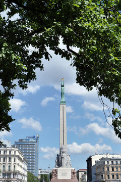 Looking up at the Freedom Monument (Brīvības piemineklis) in the centre of the city, with leaves of tree branches reaching over the top. Riga, Latvia 06 05 2024 