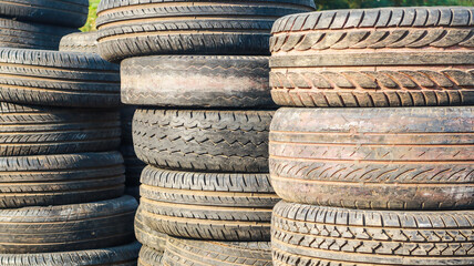 A Stack of Worn-Out Tires Backgrounds. A close-up shot of a stack of used tires, showing their worn tread and faded colors.