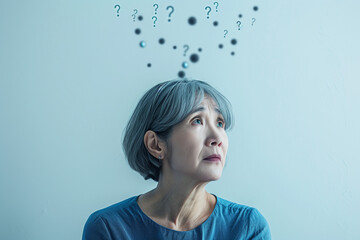 Asian elderly woman with question marks above her head, depicting confusion and uncertainty, symbolizing the struggles of dementia and memory loss.