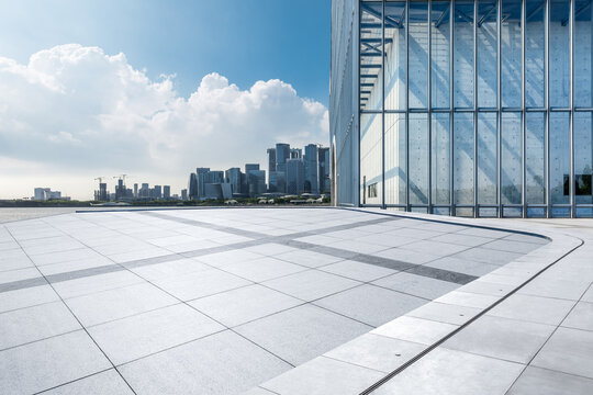 Empty square floor and glass wall with modern city buildings scenery. car background.