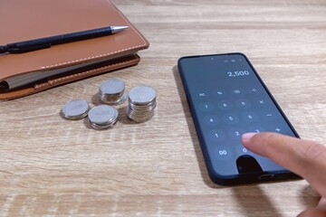 Hand using calculator apps to calculate household expenses