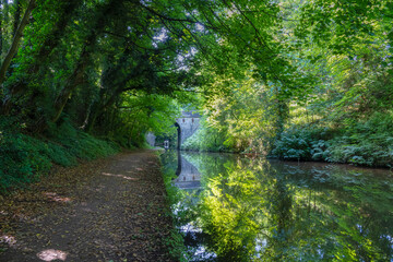 Obraz premium Canal towpath with a bridge and perfect reflections