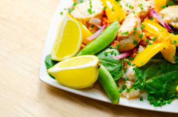 A plate of food with a yellow lemon and green peas