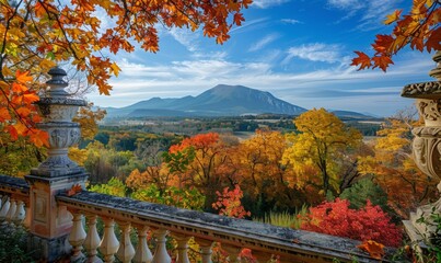 Obraz premium A vibrant autumn landscape with colorful foliage and a distant mountain, viewed from a balcony of a countryside manor