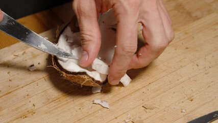 Processing a Coconut on a Wooden Board, Prizing Out the Pulp with a Knife.