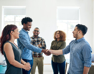 Business people, handshake and meeting for startup introduction, welcome or onboarding at creative agency. Group or graphic designer shaking hands for collaboration and hiring in office diversity