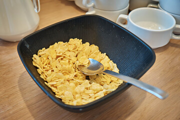 A bowl of cornflakes with a spoon. View from above. Selective focus
