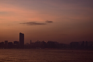 Obraz premium The view of Victoria Harbour of Hong Kong cityscape during sunset in foggy weather. Beautiful and stunning view of Hong Kong. Hong Kong Cityscape and skyline. 