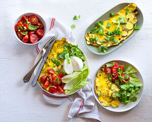 Mozzarella Bufala, omelet with zucchini, salad with tomatoes and basil, assorted lettuce leaves, delicious wonderful summer lunch. A balanced diet with fats, proteins and fiber. Mediterranean diet